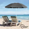 Two lounge chairs and a beach umbrella on a sandy beach with the ocean in the background. Produktbild-Vorschau