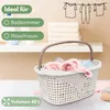 A laundry basket filled with clothes is shown on a shelf, with towels stacked behind it and a drawing of clothes on a line on the wall. Produktbild-Vorschau