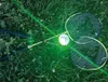 Two badminton rackets and a shuttlecock lying on grass. Produktbild-Vorschau