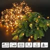 A cluster LED string light is draped over a fir tree branch, with a pile of the lights in the background. Produktbild-Vorschau