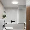 A modern bathroom with a bathtub, toilet, and a ceiling light. Produktbild-Vorschau