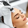 A person receiving a facial treatment with a device. Podgląd zdjęcia produktu