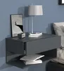 A modern gray wall-mounted nightstand with a drawer and open shelf, featuring a lamp, books, and a framed picture. Produktbild-Vorschau