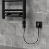 A black electric towel warmer with a digital thermostat is plugged into a wall socket. Náhled obrázku produktu