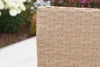 A close-up view of the woven texture of a piece of outdoor furniture, with a blurred garden background. Produktbild-Vorschau