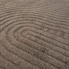 A close-up view of a textured brown carpet with a curved, ribbed pattern. Anteprima dell’immagine prodotto