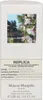 A white box for Maison Margiela Replica perfume with a picture of flowers and text describing the product. Produktbild-Vorschau