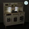 A toy kitchen set with LED lights and accessories, shown in a dimly lit room. Produktbild-Vorschau