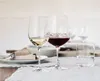 Two wine glasses, one with white wine and one with red wine, are set on a table with other tableware. Náhľad obrázku produktu