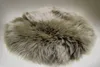 A round, fluffy sheepskin rug or cushion with brown and beige tones on a white background. Produktbild-Vorschau