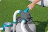 A hand is shown adjusting the valve on a pool filter pump system set up on a lawn next to a pool. Produktbild-Vorschau