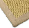 A close-up view of a sisal rug with a tan border. Voir les images du produit