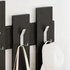 Close-up of a wall-mounted coat rack with two hooks holding items. Produktbild-Vorschau
