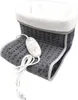 A close-up, studio shot of a gray electric foot warmer with a white fluffy lining and a white controller. Produktbild-Vorschau