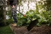 A person is using a Fiskars Solid Hacke to tend to plants in a garden. Produktbild-Vorschau