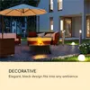 An outdoor patio scene at night with a fire pit, seating, and ambient lighting. Produktbild-Vorschau