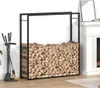 A black metal firewood rack filled with logs, placed next to a fireplace and fireplace tools. Náhľad obrázku produktu