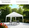 A white gazebo set up on a paved patio in a garden, with chairs and a table underneath. Náhled obrázku produktu