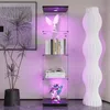 A tall display cabinet with several shelves, showcasing books, a statue, and a figurine, illuminated by purple LED lights. Náhled obrázku produktu