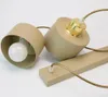Two beige pendant light fixtures with gold accents and light bulbs, lying on a white surface. Produktbild-Vorschau