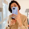 A woman is taking a selfie while holding a phone and a coffee cup. Produktbild-Vorschau