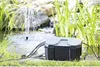 A black and gray HEISSNER Box for a garden socket is placed on the grass next to a pond with a fountain. Anteprima dell’immagine prodotto