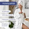 A woman wearing a white bathrobe and a towel on her head, holding a mug. Produktbild-Vorschau
