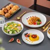A table setting with a meal, including pastries, salad, pasta, and dessert. Náhled obrázku produktu