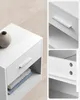 Collage of a white nightstand with a drawer and open shelf, showing detail shots of the drawer handle and interior. Produktbild-Vorschau