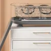 A close-up view of a portable glasses cleaning device placed on top of a white cabinet. Produktbild-Vorschau