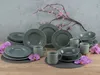 A set of gray porcelain dishes arranged on a wooden surface with pink flowers and branches in the background. Náhľad obrázku produktu