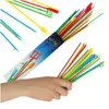 A hand holding a bundle of colorful sticks, with a packaging tube in the background. Náhled obrázku produktu