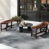 An outdoor patio scene with wooden benches and a coffee table. Anteprima dell’immagine prodotto
