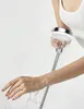 A person's arm and hand are shown being sprayed with water from a shower head. Produktbild-Vorschau