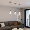 A modern living room with a sectional sofa, coffee table, and three pendant lights. Produktbild-Vorschau