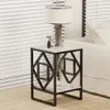A bedside table with a lamp and decorative items next to a bed with blinds in the background. Produktbild-Vorschau