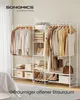 A white metal garment rack filled with clothes and accessories, set against a light gray floor and white wall. Produktbild-Vorschau
