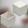Two white ceramic planters with a textured geometric pattern are shown against a blurred background. Produktbild-Vorschau