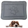 A gray dog mat with a paw print design is shown above a dog lying down. Náhled obrázku produktu