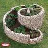 A spiral-shaped gabion planter filled with soil and various herbs and small plants, set on a grassy lawn. Produktbild-Vorschau