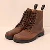 A pair of brown lace-up boots. Voir les images du produit