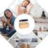 A collage of images showing a woman sleeping, a woman reading, a digital alarm clock with a phone charging on top, a kitchen counter, and a living room sofa. Produktbild-Vorschau