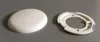 A white domed cover and a white circular base are shown on a gray surface. Produktbild-Vorschau