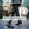 A person in a suit walking with a briefcase, with a tracker and keys on the ground, and a phone showing a map. Produktbild-Vorschau