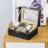 A watch organizer box with three watches inside, placed on a wooden surface. Náhľad obrázku produktu