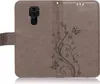 A brown flip case for a smartphone, with a floral and butterfly embossed design. Produktbild-Vorschau