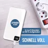 A white power bank is shown on a light wooden surface next to a white power strip with a red switch. Produktbild-Vorschau