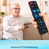 An older man is sitting on a couch, holding a remote control and looking at the camera with a smile. Another hand is holding a remote control in the foreground. Produktbild-Vorschau