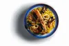 A plate of seafood paella is presented on a white surface with a shadow. Podgląd zdjęcia produktu
