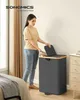 A woman is putting clothes into a laundry basket with two compartments. Produktbild-Vorschau